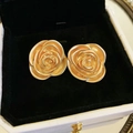 Macro shot of gold rose-shaped stud earrings displayed in a luxury black-lined jewelry box - Gold Rose Stud Earrings (Silver Pin)