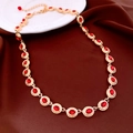 Dettaglio macro di collana dorata con gemme rosse ovali e catena regolabile rifinita - Oro-Rosso