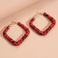 Detailweergave van vierkante oorringen met rood en zwart luipaardmotief patroon - Rode Ring