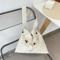 Détail du sac jacquard blanc avec chaîne perlée et texture florale sur une chaise - Sac à Épaule avec Chaîne en Perles Acryliques Vintage
