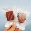 Close-up van toastvormige make-up sponsjes in matte verpakking op een blauwe achtergrond - 1 stuks Toast met willekeurige verpakking