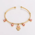 Dettaglio del bracciale ritorto dorato con perline malocchio rosse e mano di Fatima - Mano di Hamsa - Rosso