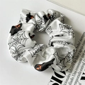 Détail d'un chouchou Halloween en satin blanc avec motifs de toiles d'araignée et fantômes - Fantôme Blanc
