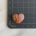 Macro detail of a 1.5cm heart-shaped resin bread charm with nut texture and white drizzle - Heart Chocolate