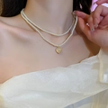 Detailaufnahme einer zweireihigen Perlenkette mit goldenem Herzanhänger am Model - 25# Halskette-Weiße Herzperle (Doppellagige Feine Kette)