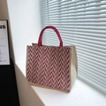 Striped jute tote bag featuring red and white chevron patterns and round woven handles - Red