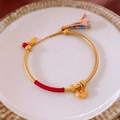 Détail du bracelet gourde dorée avec fil rouge, pompon et breloque cadenas de chance - Jonc Ruyi de Style Ancien Or Rouge