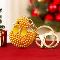 Beaded yellow duck keychain with golden lobster clasp and festive red backdrop - Yellow Pearl Duck