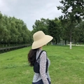 Outdoor lifestyle view of a woman wearing a black brim straw hat and leopard print shirt - Adjustable / Beige Wide Brim
