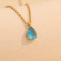 Golden necklace featuring a light blue pear-cut gemstone pendant with a faceted finish - December (Light Blue)