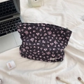 Detailed top view of black floral quilted makeup bag with pink flowers and La Mer skincare - Black with Pink Floral