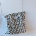 Dettaglio della borsa tote in tela floreale con tracolla in tessuto e etichetta - Nero Con Piccoli Fiori Bianchi