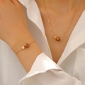 Goldenes Schmuckset mit Herz und Basketball-Anhänger an einem weiblichen Model - Halskette Armband Set (Basketball)