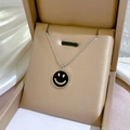 Detail einer silbernen Kugelkette mit schwarzem Smiley-Anhänger in einer Schmuckschatulle - Silber/Schwarzes Email (K326)