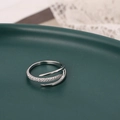 Eleganter silberner dreilagiger offener Ring mit Zirkonia auf einem grünen Keramikteller - L3402 Stil / Silber