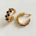 Golden C-shaped hoop earrings featuring double rows of black and white cubic zirconia - Black Zirconia / Gold