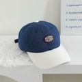 Dettaglio cappellino da baseball in denim blu scuro con visiera bianca e ricami - 52cm (2-5 Anni Regolabile) / Blu Notte e Bianco