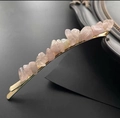 Close-up of pink natural crystal stones set on a golden metal hair clip accessory - Rose Quartz Gold