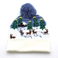 Dettaglio del berretto in maglia natalizio con motivi di renne e alberi e pompon blu morbido - Stile Renna e baita con albero di Natale