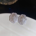 Detailed close-up of hollow oval stud earrings with silver plating and sparkling zircons - Silver