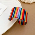 Gedetailleerd beeld van een brede C-vormige acryl armband met gekleurde verticale strepen - Pop regenboog gestreepte stijl