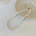 Détail d'un collier de perles d'eau douce baroques avec fermoir doré et extension - Collier de perles baroques / Blanc