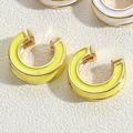 Close-up of C-shaped hoop earrings with bright yellow enamel and gold metallic trim - Yellow