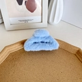 Pinza per capelli in peluche azzurro a forma di mezzaluna su un vassoio di legno sobrio - Celeste