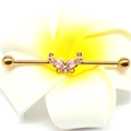 Close-up of golden industrial barbell earring featuring a pink zircon butterfly charm - Gold Butterfly/Pink Zircon / Gold