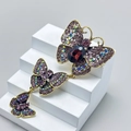 Three-tier gold butterfly brooch with purple rhinestones and red oval gemstone - Style 72/Long Purple Gem Butterfly