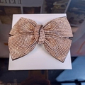 Close-up of sparkling rose gold rhinestone bow hair clip showing detailed pavé crystal setting - Champagne
