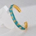 Macro detail van de vergulde armband met turquoise emaille en glanzende kristallen bloemen - Blauw