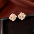 Macro view of gold plated flower earrings with sparkling zircons on black jewelry box - Gold