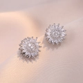 Macro detail of silver sunflower earrings with sparkling crystals on a beige satin background - E0675 Steel Color --2