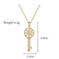 Dettaglio di un ciondolo a chiave dorata con design floreale e cristalli, alto 3,9 cm - Stile Chiave Stella (C104) / Oro
