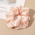 Detailed view of peach pink silk satin scrunchie with smooth glossy texture and ruffles - Off White