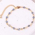 Dettaglio di un bracciale placcato oro con zircone blu e chiusura a moschettone regolabile - Bracciale / Blu