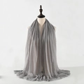 Detail showing the gray crinkled cotton-linen scarf with fringed edges on a model - Grey