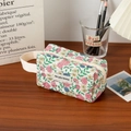 Detail of floral quilted makeup bag with soft cotton texture and branded woven label - Small Wristlet Bag