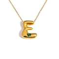 Detail of 18k gold plated bubble letter E pendant with a small green heart gemstone - Letter E