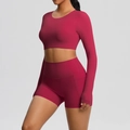 Detail van high-waist yogashorts met zijzakken en crop top met lange mouwen in donkerrood - Karmijnrood