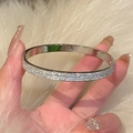 Dettaglio del bracciale d'argento scintillante con cristalli pavé su pelliccia bianca - Argento