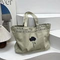 Large beige canvas tote bag with black floral print and NKK ART STUDIO text - Gray