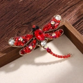 Vintage style dragonfly brooch featuring vibrant red crystals and antique gold finish - Red