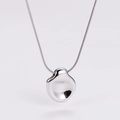 Macro view of irregular organic pendant with high-mirror finish on fine snake chain - Steel