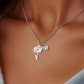Detail showing a silver daisy charm and a sparkling round zircon on a thin chain necklace - April