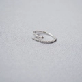 Macro shot of silver snake-shaped ring featuring sparkling pavé crystals on a soft grey cloth - Adjustable Open / Silver
