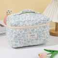 Close-up of blue floral quilted cotton makeup bag featuring soft texture and woven label - White Base Blue Orchid