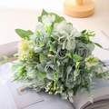 Ramo artificial con rosas de seda verde grisáceo y follaje sobre una revista - Verde