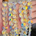 Macro shot of faceted crystal heart beads with AB rainbow iridescent coating in hand - 10mm Straight Hole / New AB Color